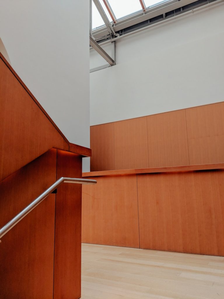 an empty room with wooden walls and a metal hand rail