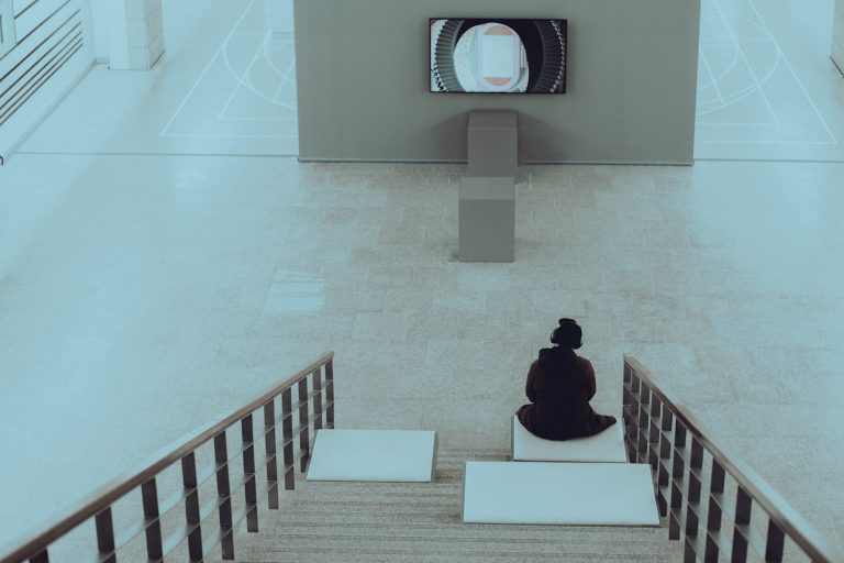 a person sitting on a bench in front of a tv