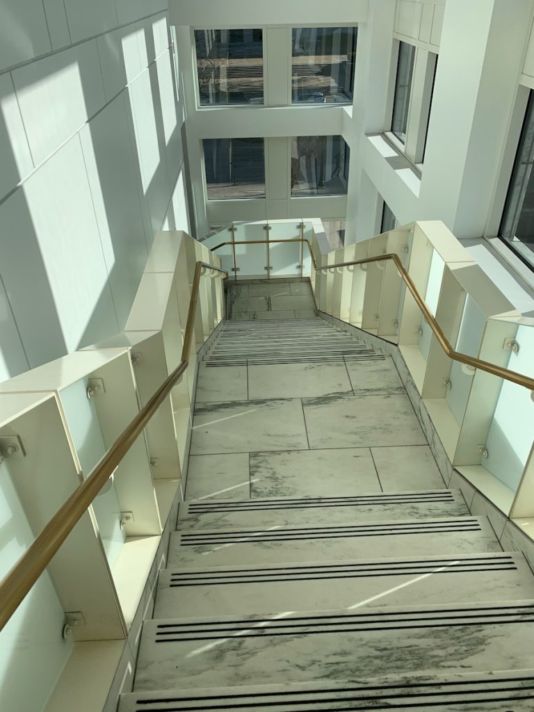 a long hallway with a set of stairs leading up to a window