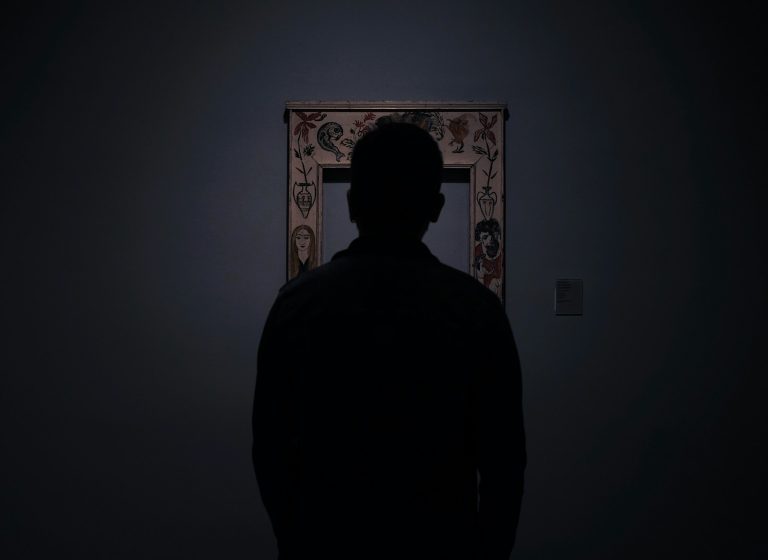 silhouette of person facing an empty photo frame